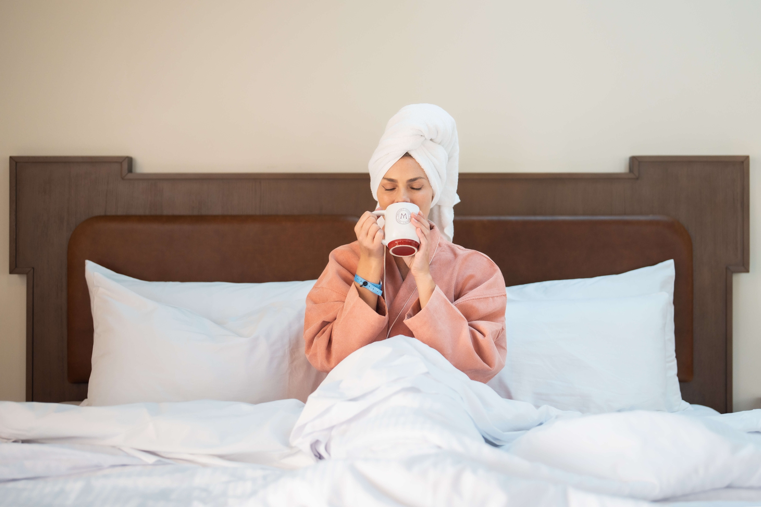 Person Relaxing in Hotel Room Bed